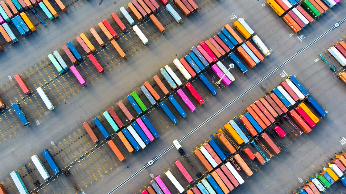 Overhead view of shipping containers in container yard for compliant and efficient government and commercial logistics, SAM.gov-registered small business.